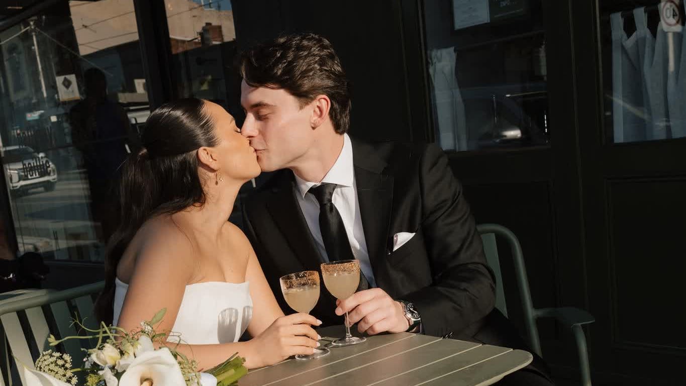 Newly married couple toasting with cocktails outside a Melbourne bar after their wedding ceremony